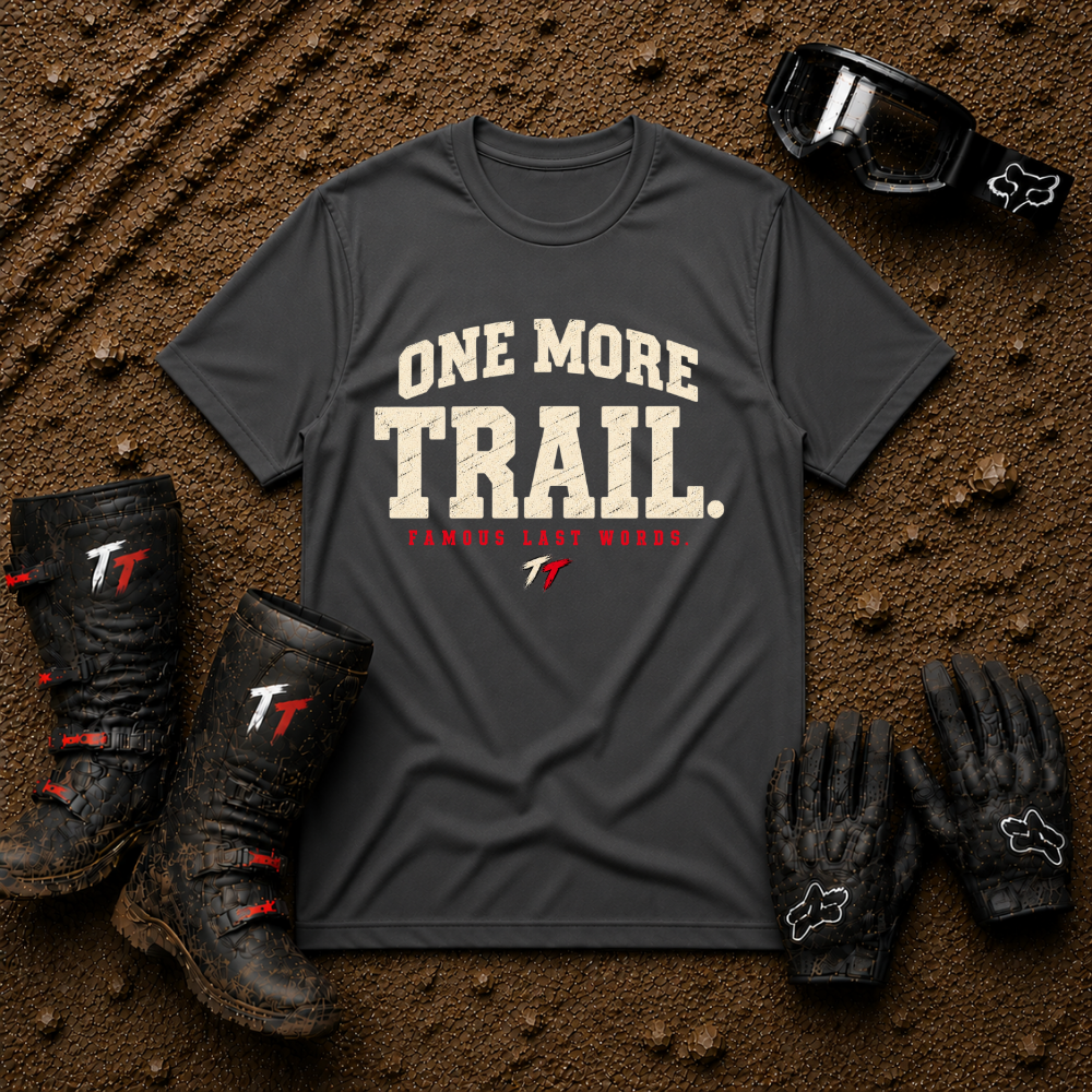 Dark Heather grey One More Trail t-shirt with vintage varsity print and 'Famous Last Words' tagline — flat lay with muddy boots, goggles, and gloves, Tire Time Offroad
