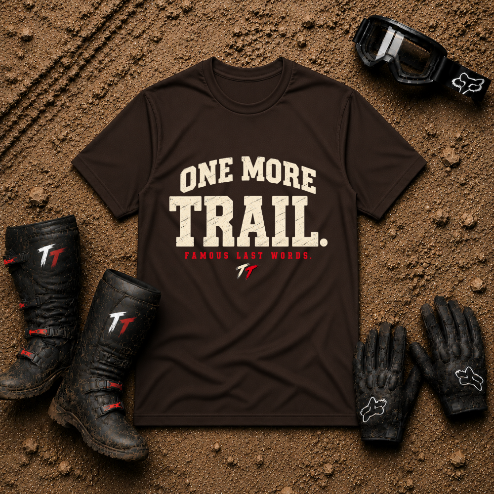 Dark Chocolate brown One More Trail t-shirt with vintage varsity print and 'Famous Last Words' tagline — flat lay with muddy boots, goggles, and gloves, Tire Time Offroad